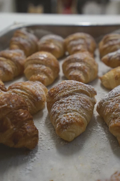 croissants in a tray with icing sugar