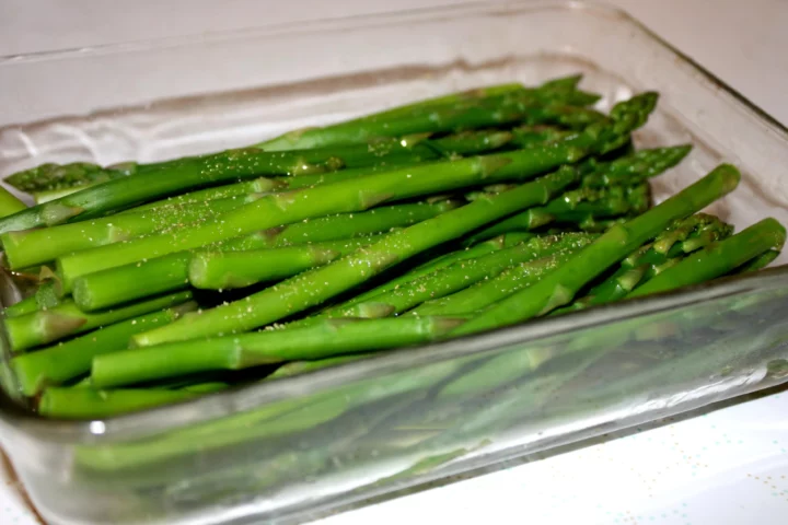 asparagus in water in glass tray