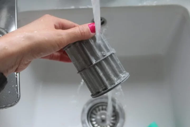 dishwasher filter being cleaned