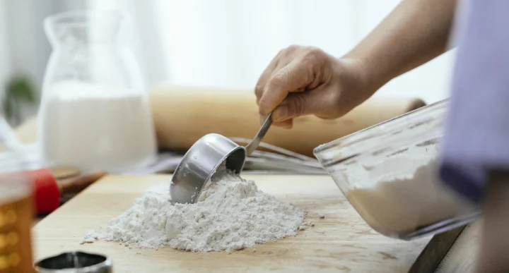 woman putting flour on wooden board