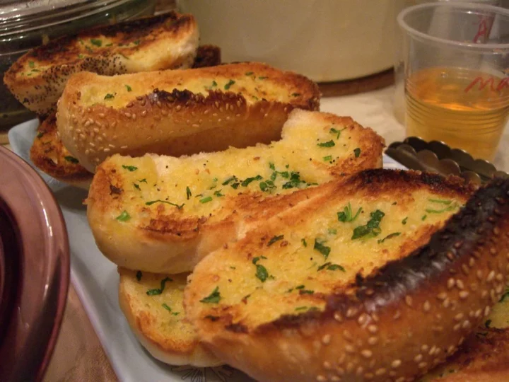 multiple pieces of garlic bread with tongs